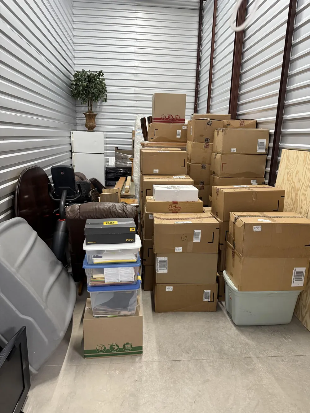A storage unit stacked neatly with boxes, bins and furniture