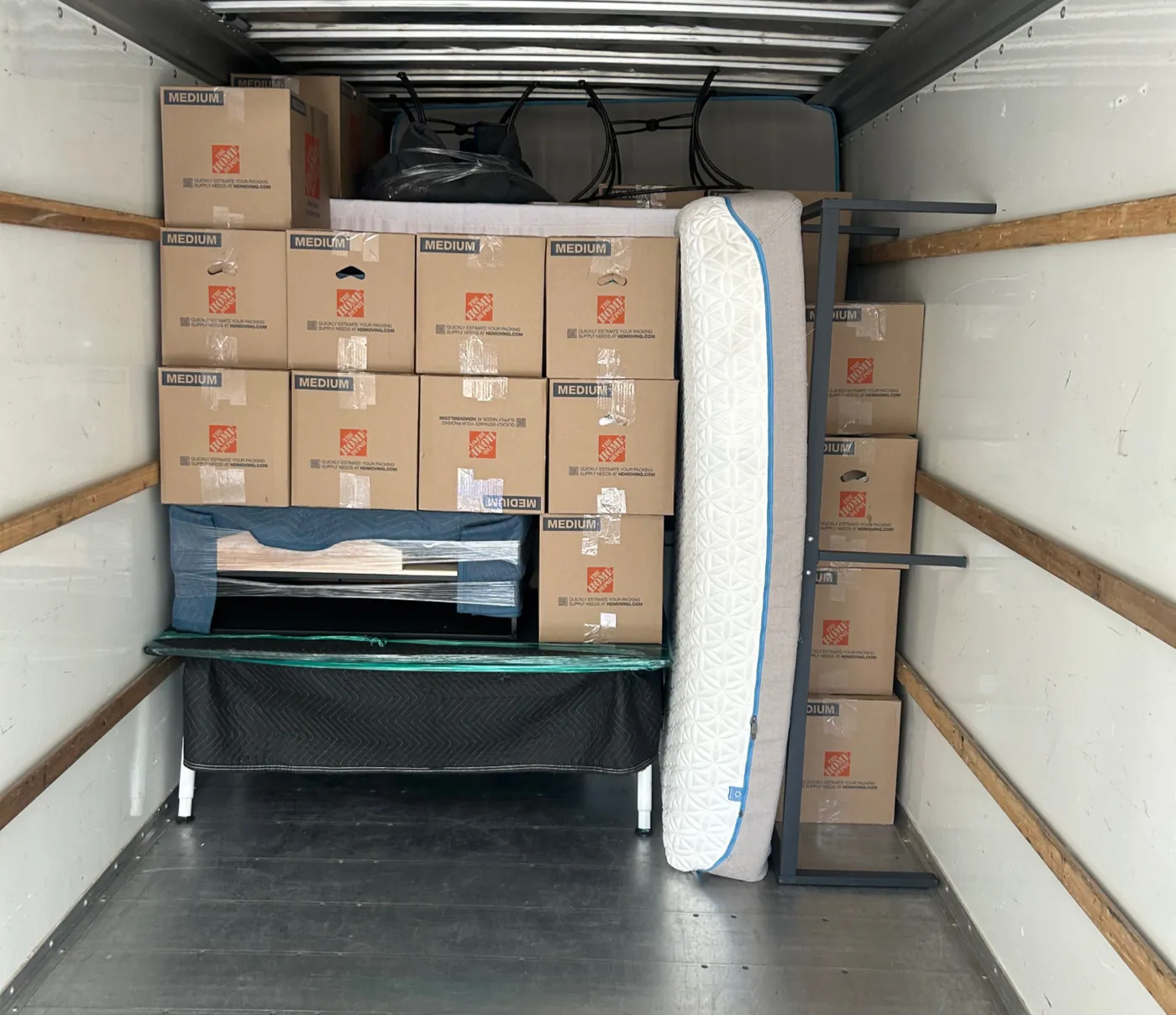 A truck packed with uniform boxes, a mattress and a padded table
